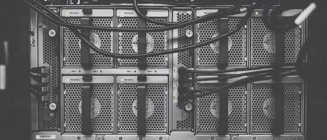 The back of a server rack with multiple connected devices and wires.
