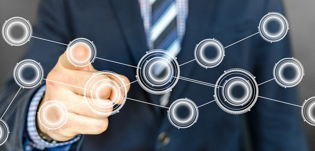 A business person interacting with a digital network interface by pointing at circular icons.