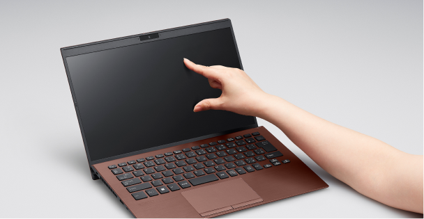 Person interacting with a VAIO laptop touchscreen, highlighting its responsive display and sleek, modern design.