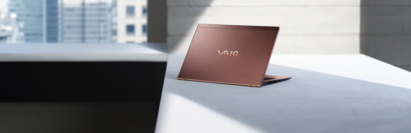 Sleek VAIO laptop in a stylish brown finish, placed on a modern desk with a city view in the background