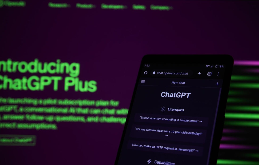 A smartphone displaying the ChatGPT interface with the ChatGPT Plus introduction on a website in the background.