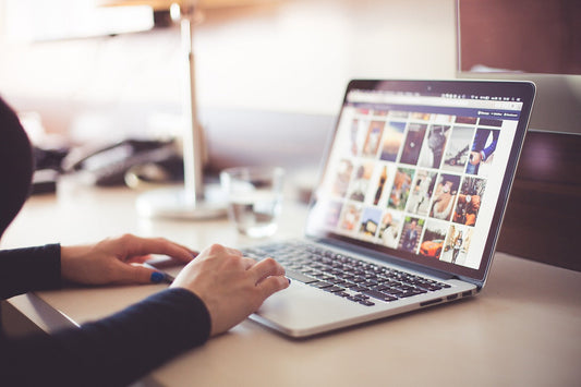 Person using a laptop to browse through image galleries on a website.