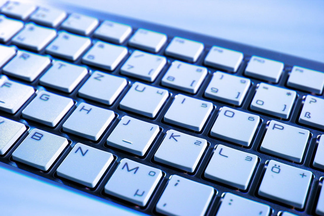 A close-up of a laptop keyboard, featuring white keys with alphanumeric characters and symbols.