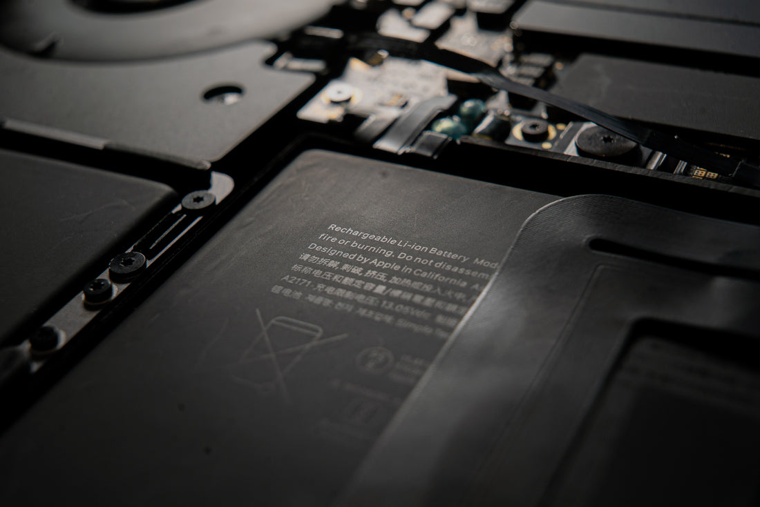 A close-up of a laptop's internal components, including the rechargeable battery.